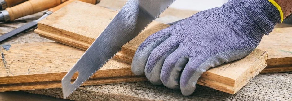 Hand sägt Holz mit Säge